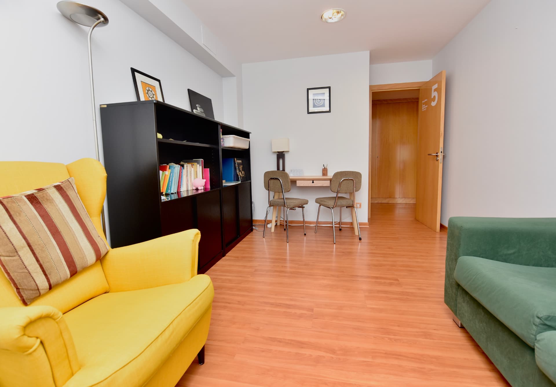 Zona de descanso de CNG Solutio Lugo con sillón, sofá y escritorio junto a una estantería